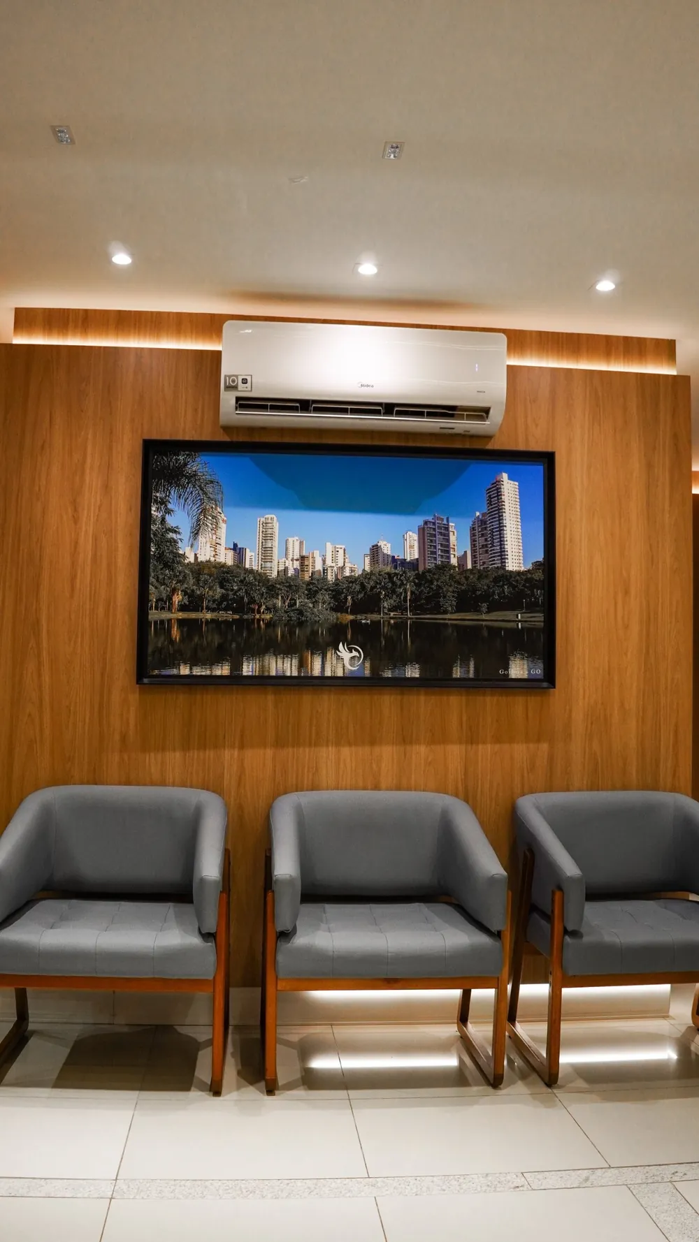 Sala de espera da unidade Goiânia, com poltronas e um quadro da cidade